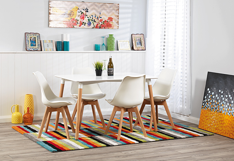 Modern, Scandinavian style dining table with white top and wooden legs. With matching white chairs in bright interior space. 